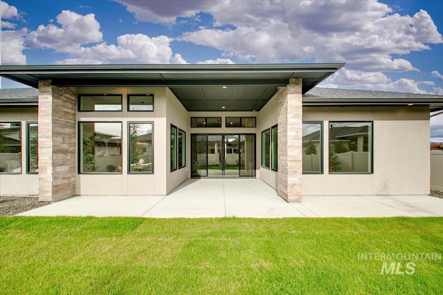 rear view of house with a yard and a patio