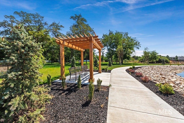 view of property's community with a lawn and a pergola