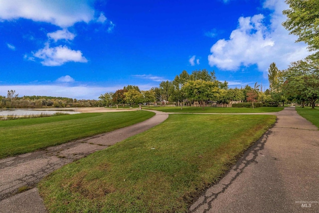 surrounding community featuring a lawn and a water view