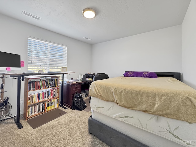 carpeted bedroom with visible vents and a textured ceiling