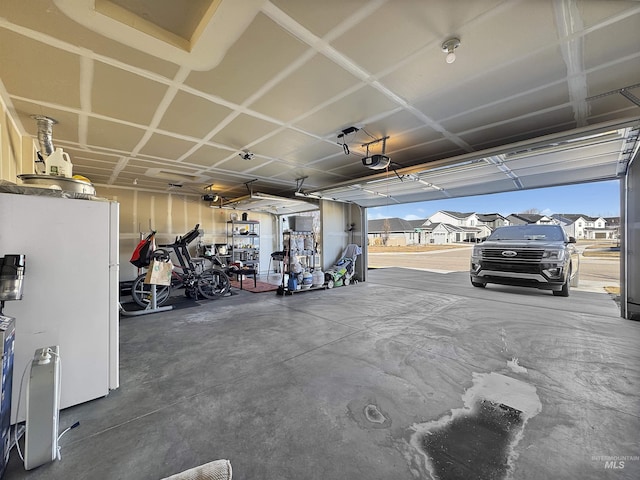 garage with freestanding refrigerator and a garage door opener