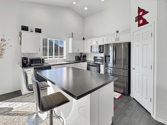 kitchen with white cabinets, dark countertops, black appliances, high vaulted ceiling, and a sink