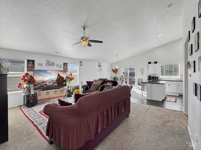 living room featuring vaulted ceiling, ceiling fan, a textured ceiling, and dark carpet