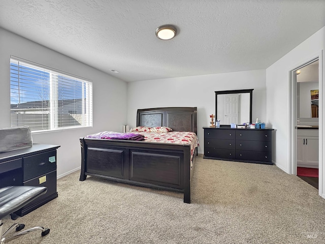 bedroom featuring carpet floors, connected bathroom, a textured ceiling, and baseboards