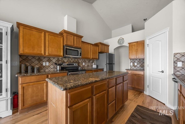 160 Summit Ridge Rd, Horseshoe Bend, ID 83629 - kitchen featuring stainless steel appliances, a center island, backsplash, light wood-type flooring, and dark stone counters