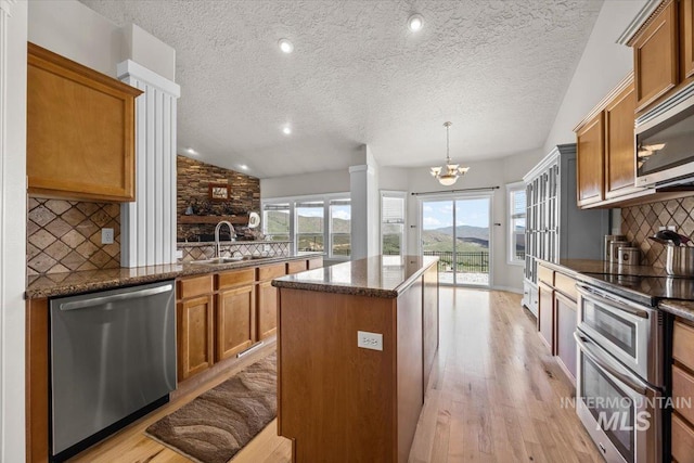 160 Summit Ridge Rd, Horseshoe Bend, ID 83629 - kitchen with stainless steel appliances, a textured ceiling, a sink, light wood-type flooring, and brown cabinetry