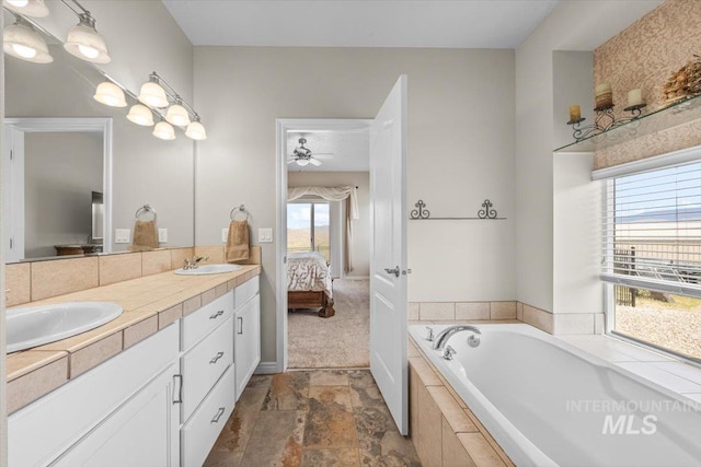 160 Summit Ridge Rd, Horseshoe Bend, ID 83629 - ensuite bathroom featuring double vanity, a garden tub, a ceiling fan, and stone finish floors