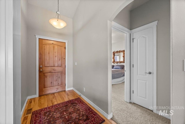 160 Summit Ridge Rd, Horseshoe Bend, ID 83629 - foyer with arched walkways, baseboards, light wood-style floors, and vaulted ceiling