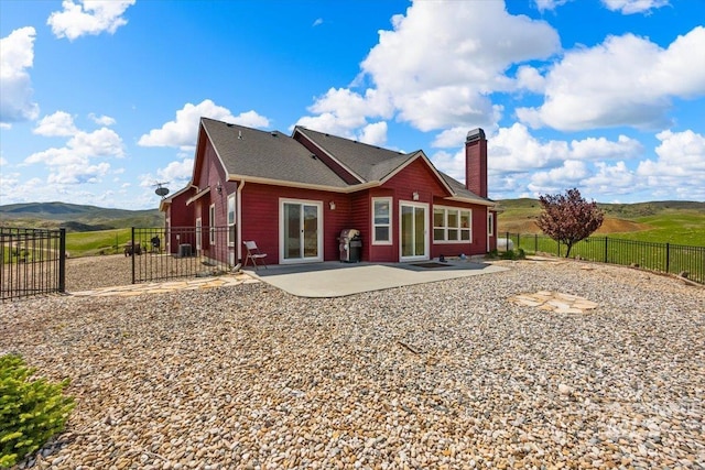 160 Summit Ridge Rd, Horseshoe Bend, ID 83629 - back of property featuring a patio area, a chimney, a fenced backyard, and a mountain view