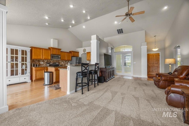 160 Summit Ridge Rd, Horseshoe Bend, ID 83629 - kitchen featuring open floor plan, stainless steel appliances, light colored carpet, brown cabinetry, and a kitchen bar