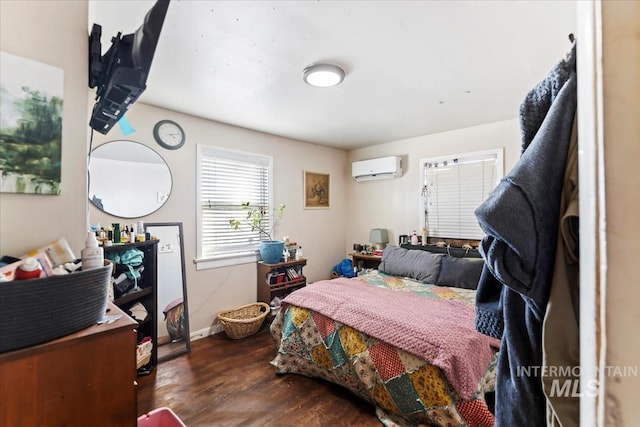 bedroom featuring dark hardwood / wood-style flooring and a wall unit AC