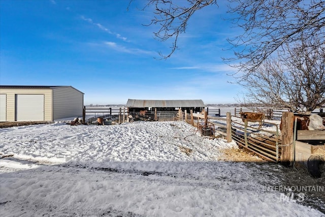 yard layered in snow featuring an outdoor structure