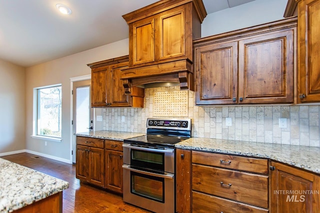 kitchen with electric range, light stone counters, dark hardwood / wood-style floors, backsplash, and custom exhaust hood