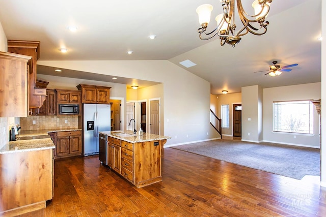 kitchen featuring sink, stainless steel appliances, tasteful backsplash, a kitchen island with sink, and ceiling fan with notable chandelier