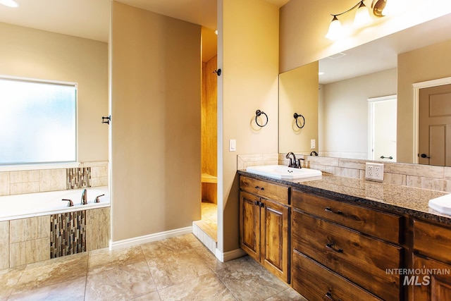 bathroom with tiled bath and vanity