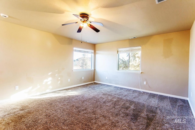 empty room featuring carpet flooring, ceiling fan, and a healthy amount of sunlight