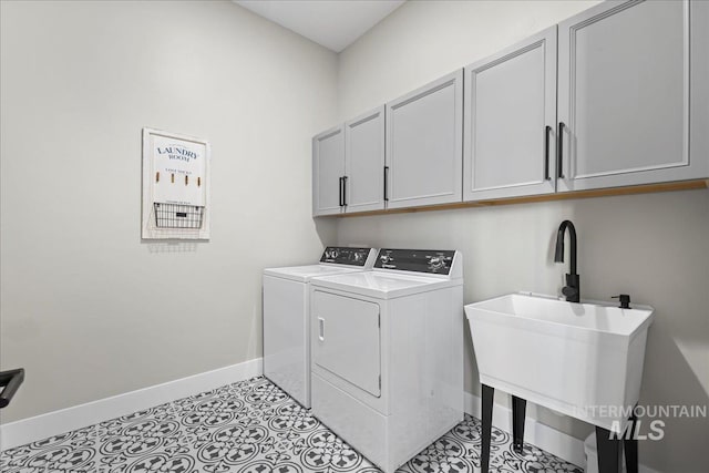 laundry room featuring washing machine and dryer, cabinet space, baseboards, and light tile patterned floors