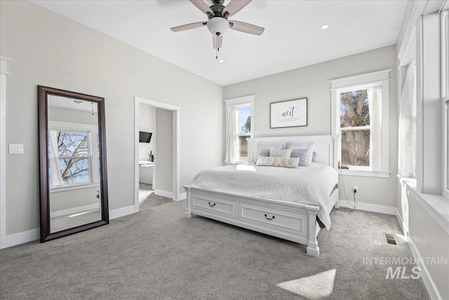 bedroom with ceiling fan, connected bathroom, light colored carpet, visible vents, and baseboards