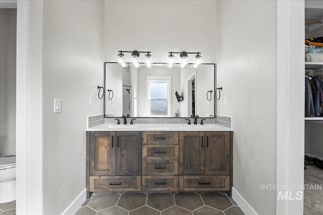 full bath featuring a spacious closet, tile patterned flooring, and a sink