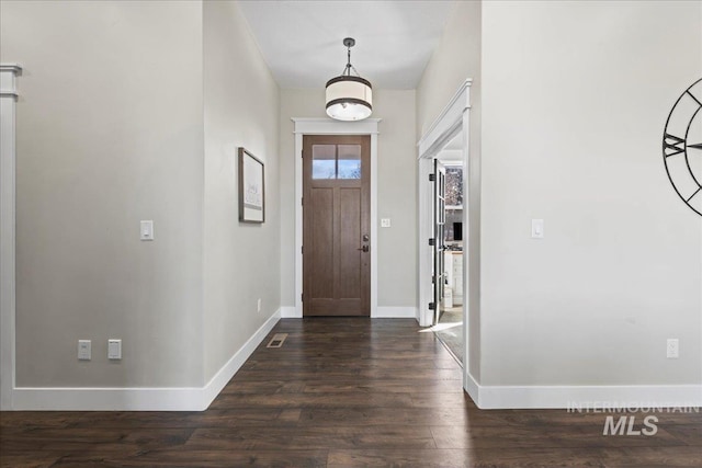 foyer entrance featuring baseboards and dark wood-style flooring