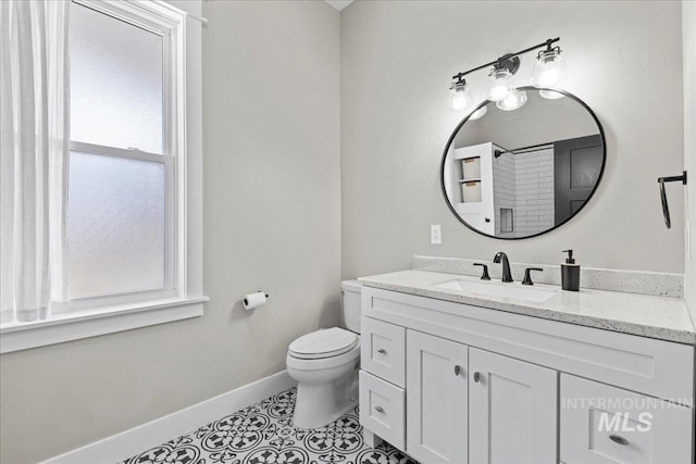 bathroom featuring toilet, tile patterned floors, baseboards, and vanity