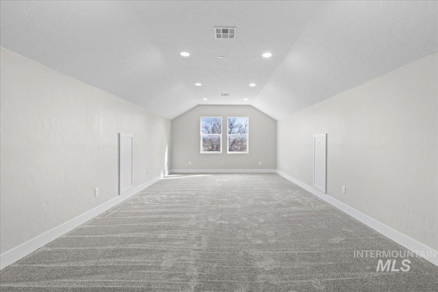 bonus room with vaulted ceiling, carpet floors, visible vents, and baseboards