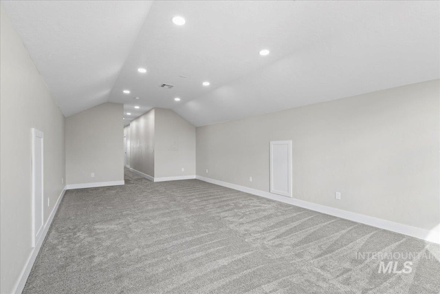 bonus room featuring lofted ceiling, recessed lighting, light colored carpet, visible vents, and baseboards