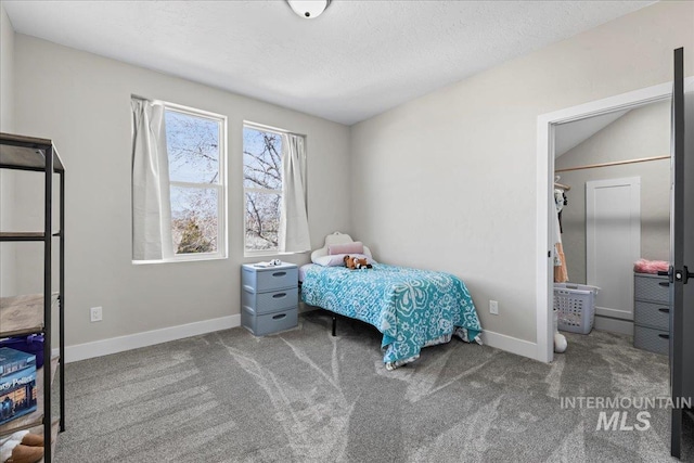 bedroom with a textured ceiling, carpet floors, and baseboards