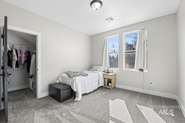 carpeted bedroom featuring a closet, visible vents, a spacious closet, and baseboards