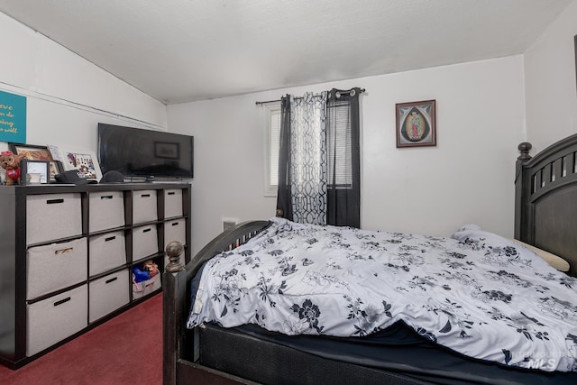 bedroom with dark carpet, lofted ceiling, and a textured ceiling