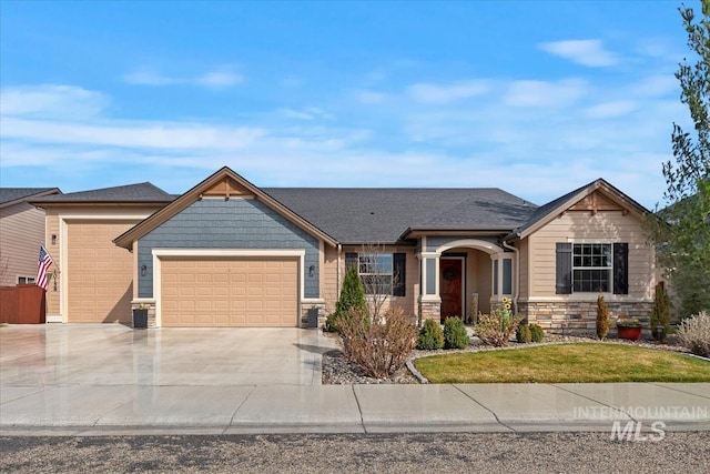 craftsman-style home with a front lawn, an attached garage, stone siding, and driveway