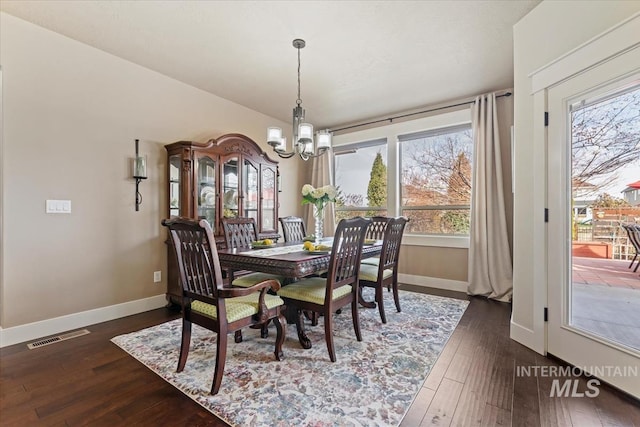 dining space with visible vents, baseboards, dark wood-type flooring, and a notable chandelier