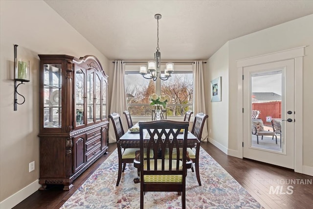 dining space featuring a notable chandelier, dark wood-type flooring, and baseboards