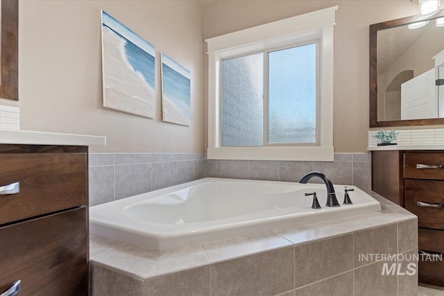 full bathroom with a bath and vanity