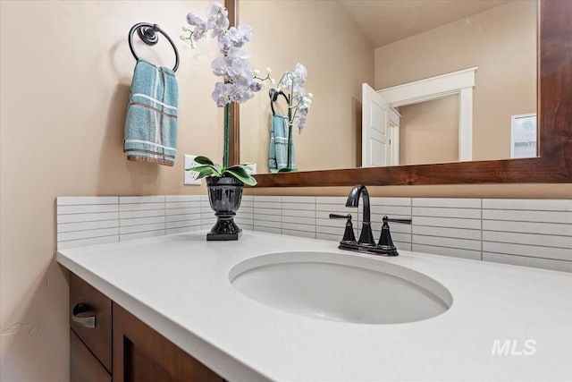 interior details featuring vanity and tasteful backsplash