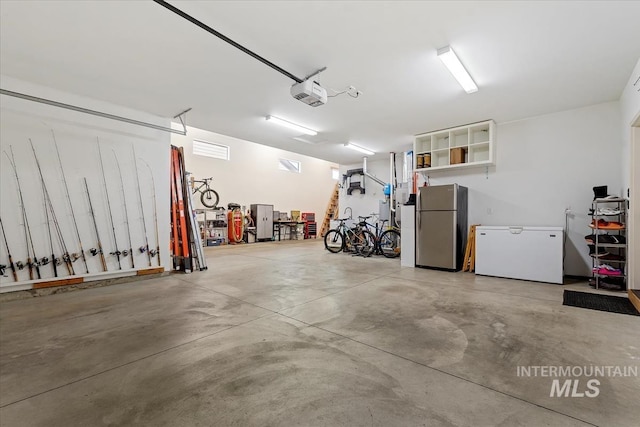 garage with fridge, a garage door opener, and freestanding refrigerator