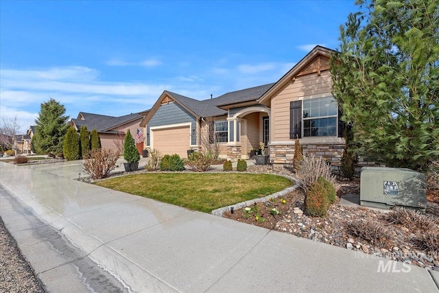 view of front facade featuring stone siding, an attached garage, concrete driveway, and a front yard