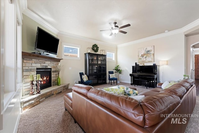 carpeted living room featuring a fireplace, baseboards, a ceiling fan, and ornamental molding