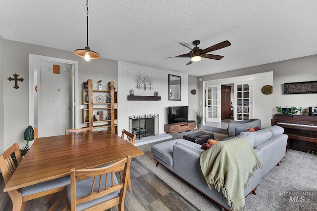 713 E Harcourt Rd, Boise, ID 83702 - living room with a ceiling fan, a textured ceiling, a fireplace, wood finished floors, and french doors
