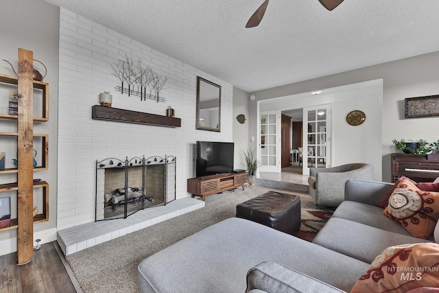 713 E Harcourt Rd, Boise, ID 83702 - living area with a textured ceiling, a fireplace, wood finished floors, and ceiling fan