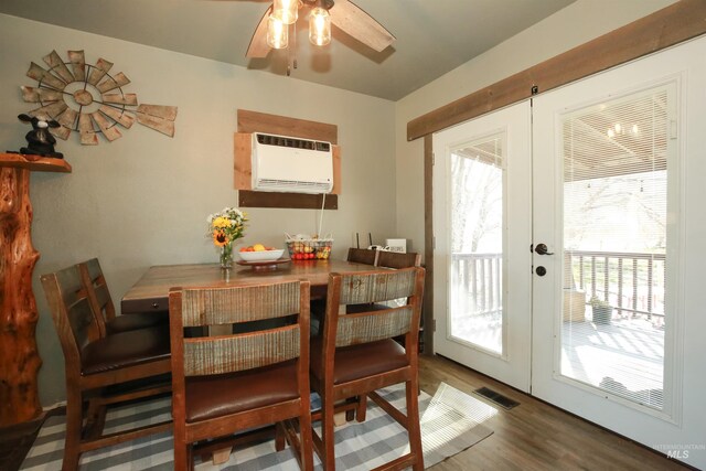 dining room with ceiling fan, dark hardwood / wood-style floors, a wall unit AC, and french doors