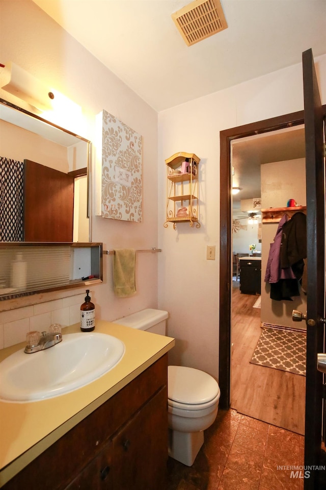 bathroom featuring tile flooring, toilet, and vanity