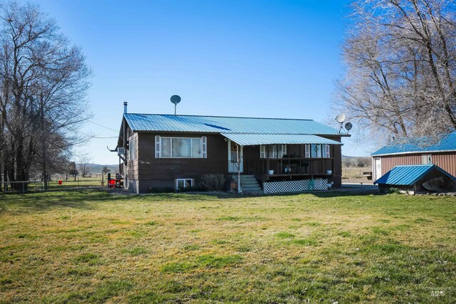 back of house featuring covered porch and a yard