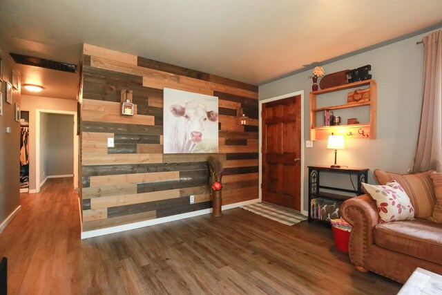 sitting room featuring wood walls and dark wood-type flooring