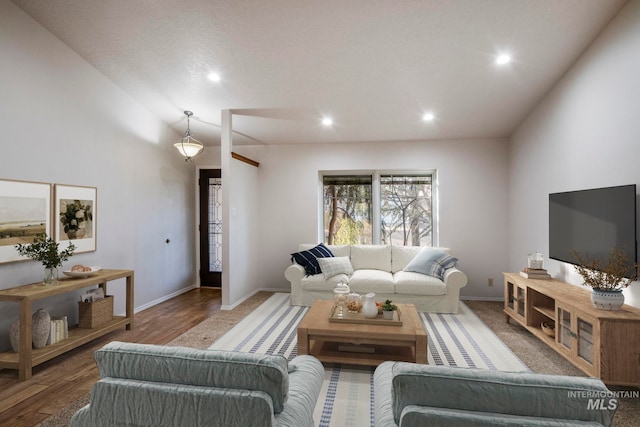 living area featuring lofted ceiling, recessed lighting, baseboards, and wood finished floors