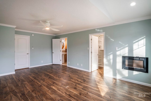 unfurnished living room with dark wood-type flooring, crown molding, baseboards, and a ceiling fan