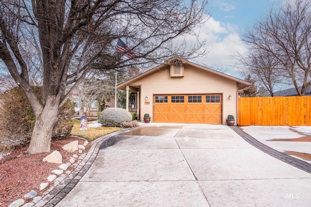 exterior space featuring driveway, an attached garage, and fence