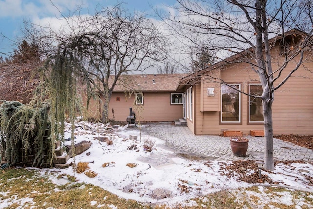 snow covered property with a patio