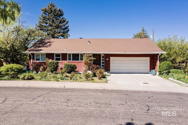 ranch-style home featuring a garage, brick siding, and concrete driveway