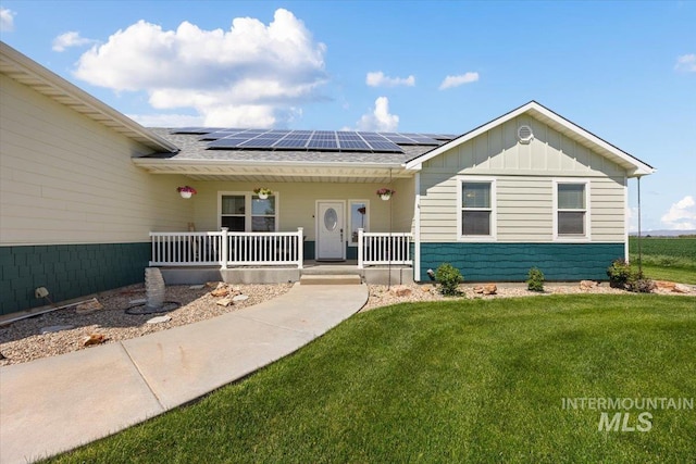 3415 Marble Front Rd, Caldwell, ID 83605 - view of front of house featuring covered porch, board and batten siding, a front lawn, and solar panels